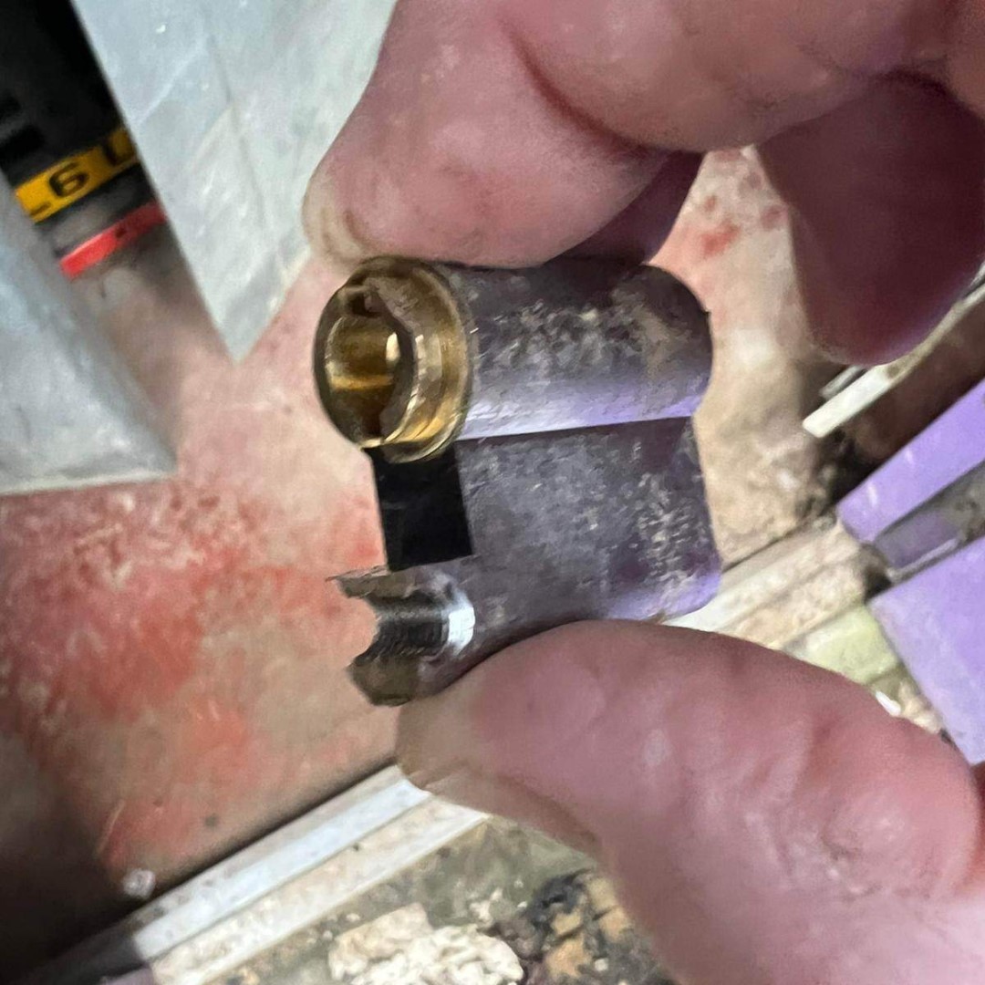 Snapped euro lock being held in hand showing lock broken at its weakest point 