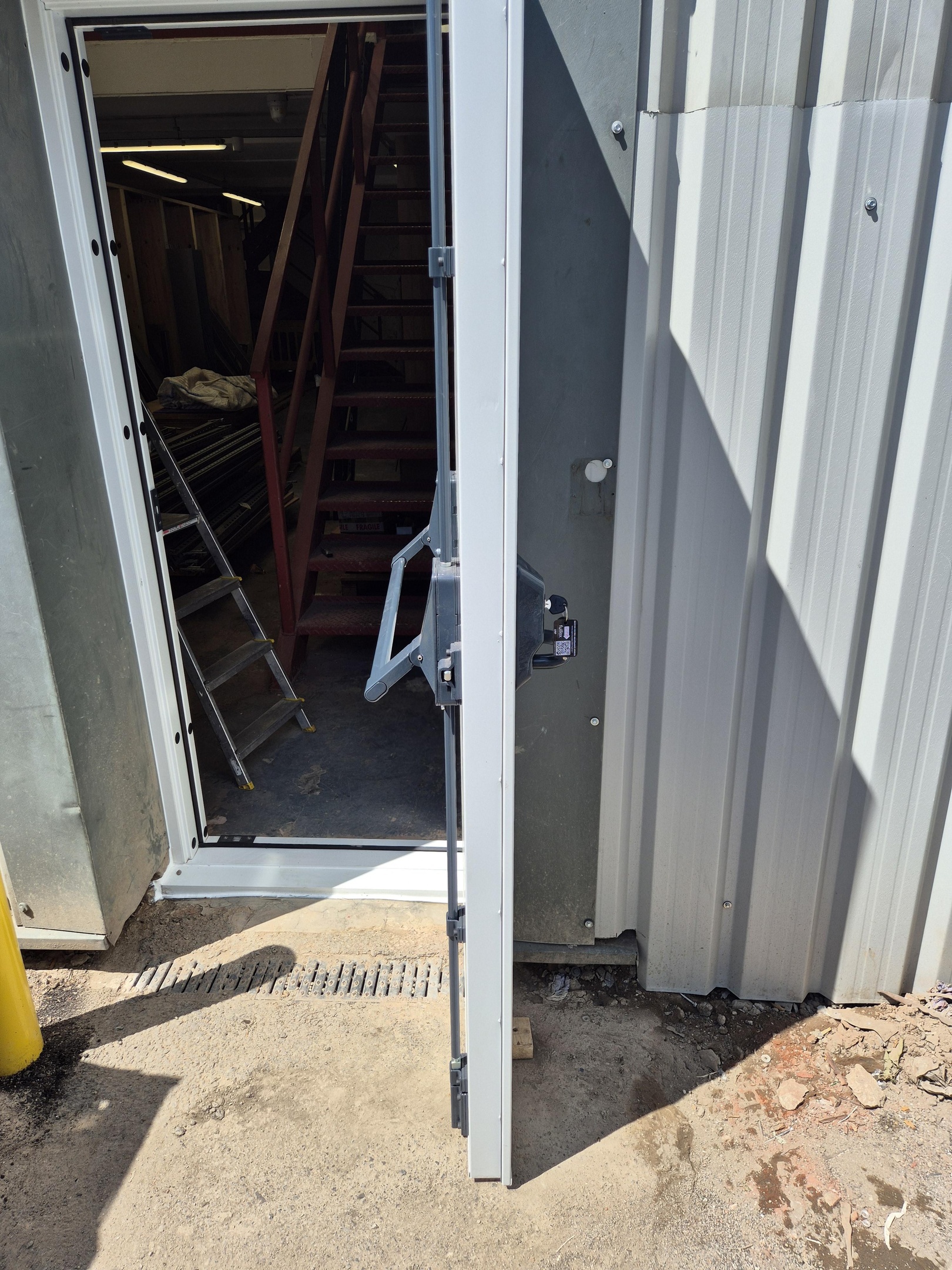White commercial door in open position with Exidor panic device