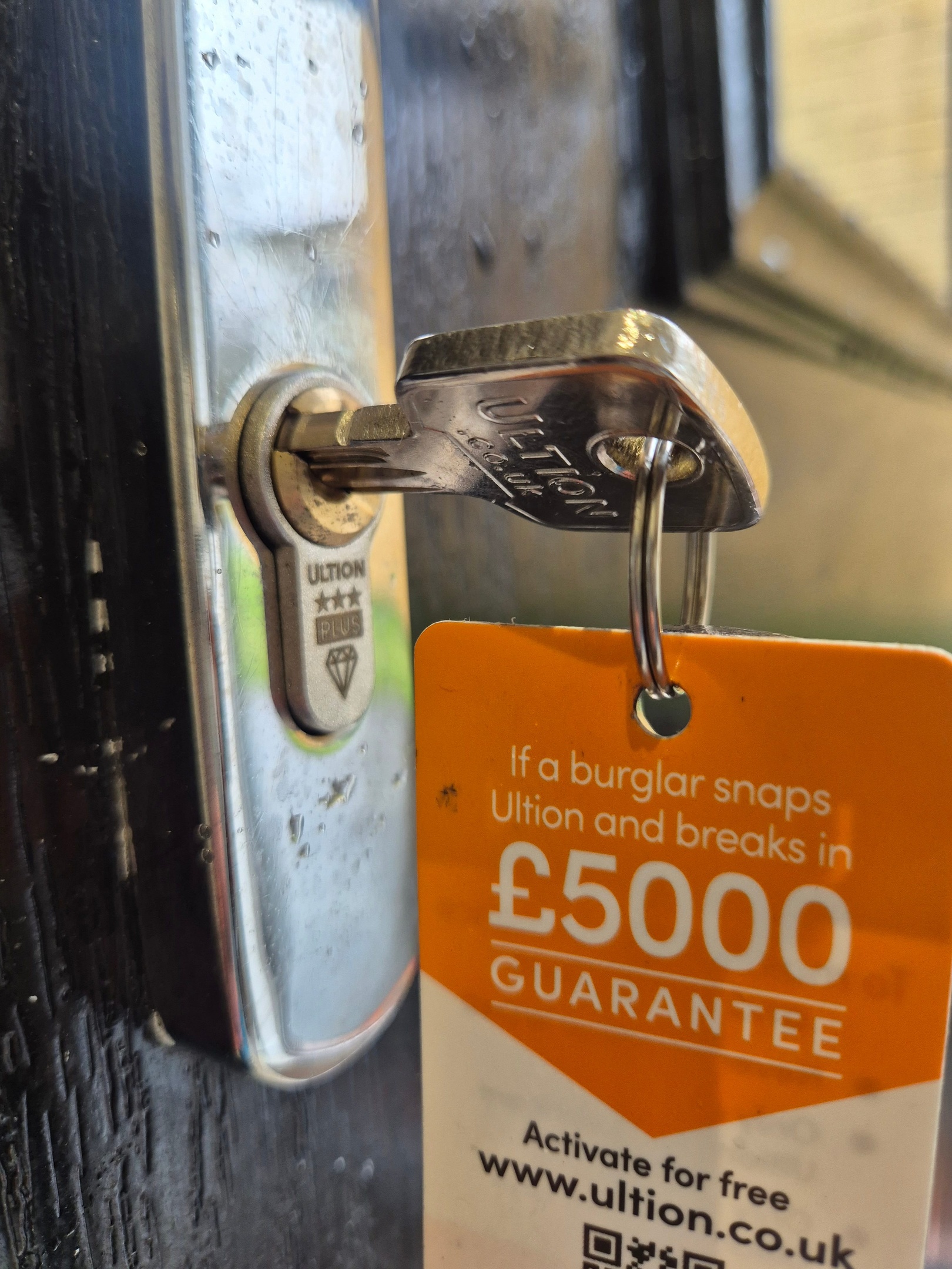 Ultion anti snap lock showing lock cylinder, key and orange £5000 security guarantee card