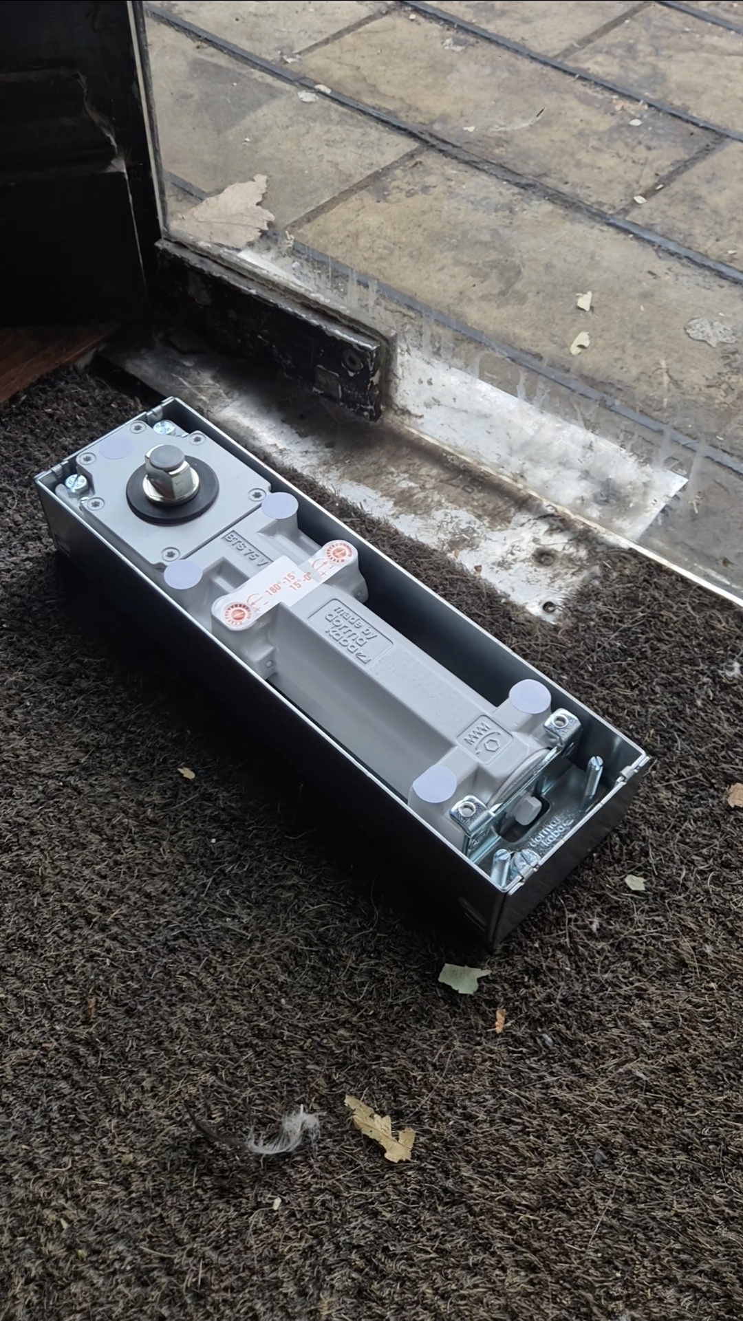 Dorma glass door floor closer laid next to glass door 