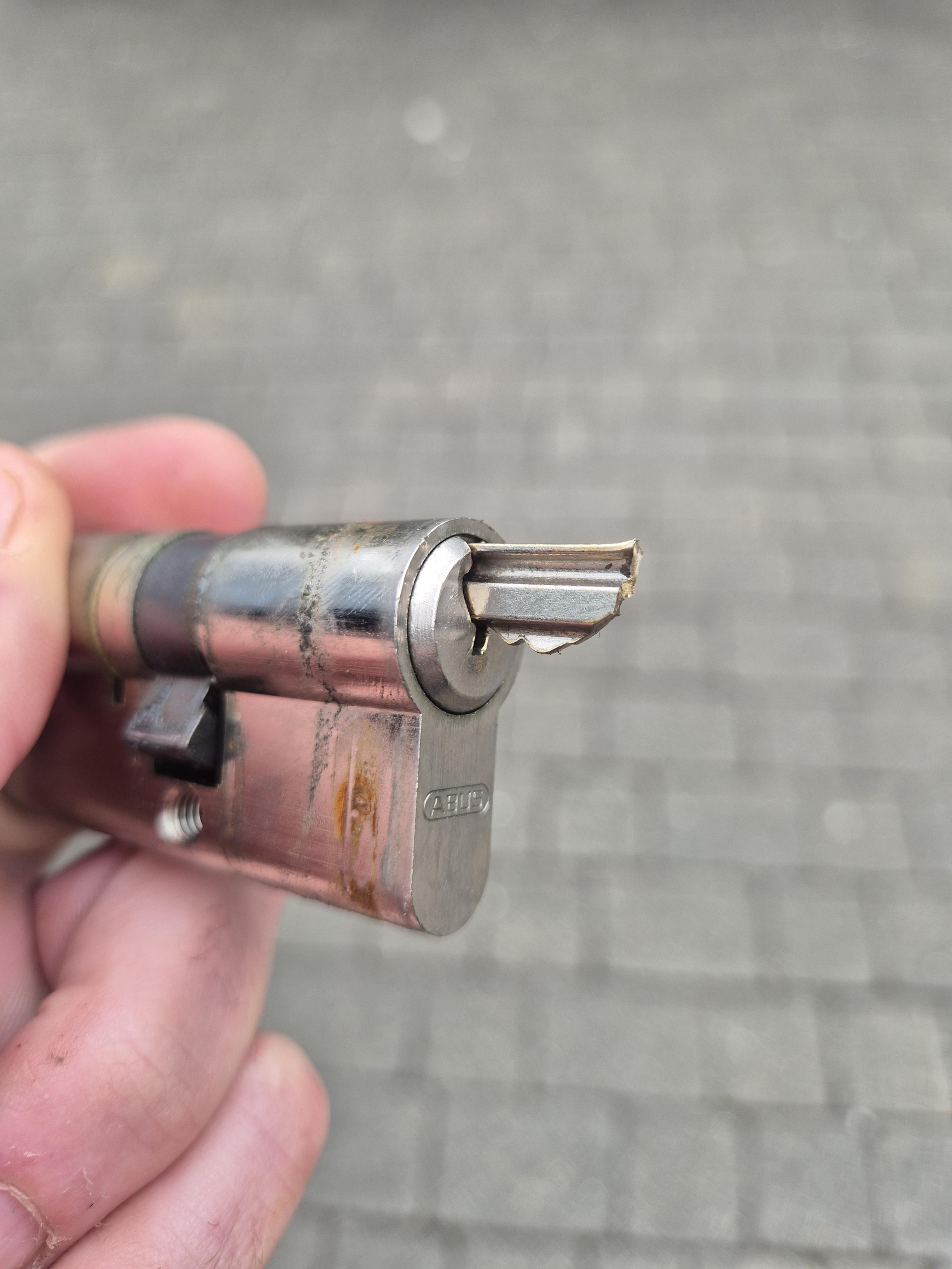 Chrome euro lock with silver key extracted being held in hand 