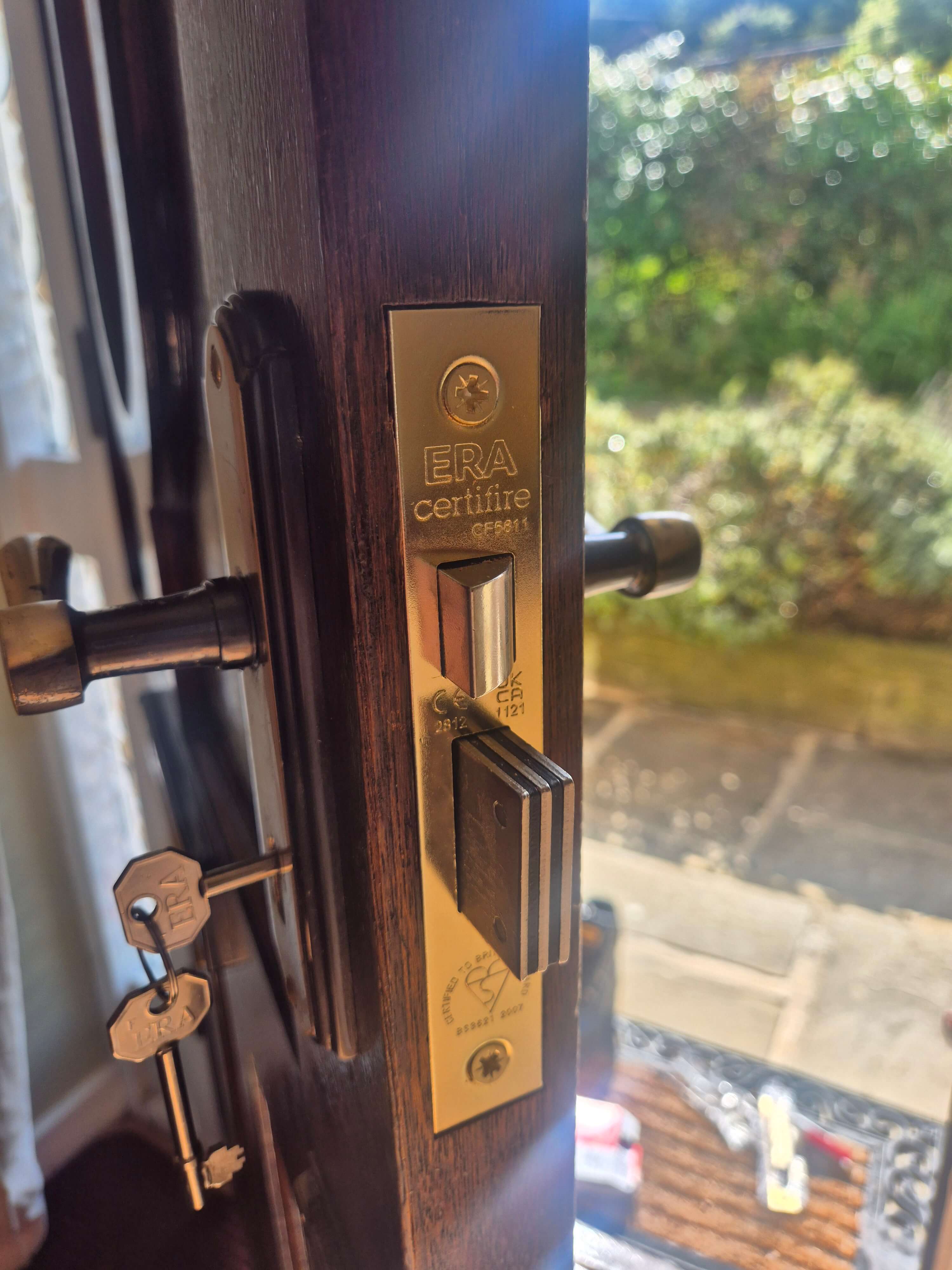 BS3621 Era Fortress sash lock finished in brass fitted to a brown wooden door
