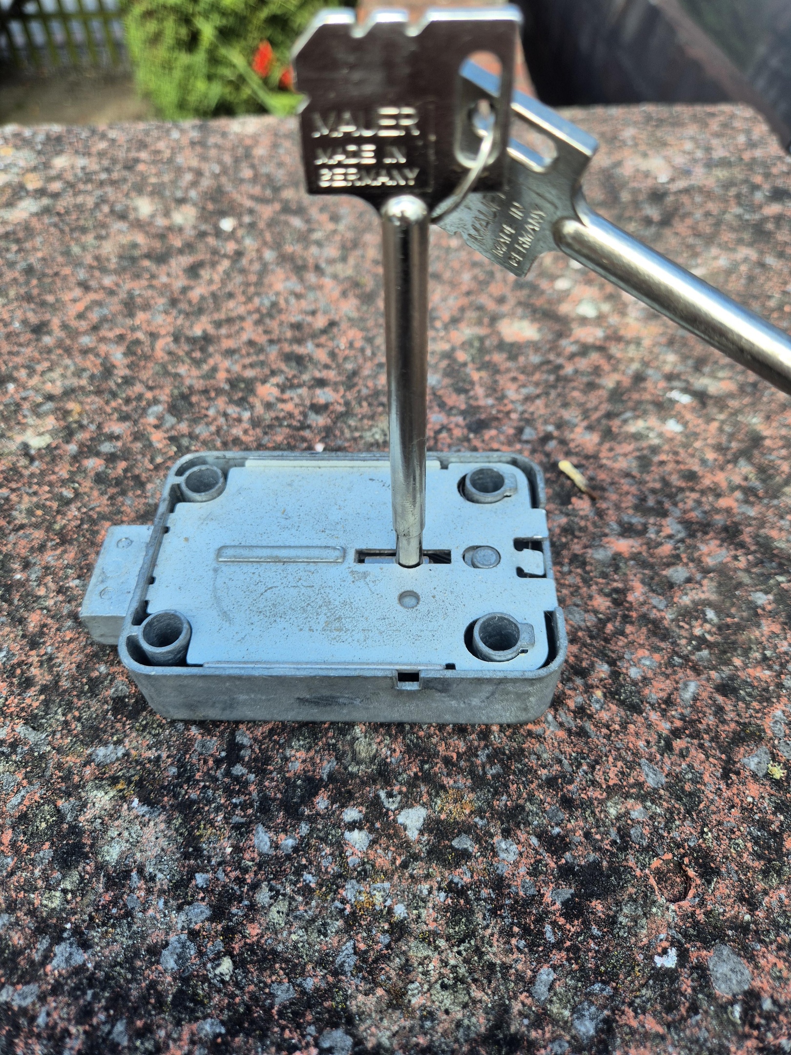 Safe lock laid on brick with safe key inserted